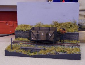 Narrow-gauge diorama, open coal truck being loaded by hand